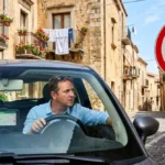 Conducteur perplexe face à un panneau ZTL dans une rue étroite, une erreur à éviter en Sicile.
