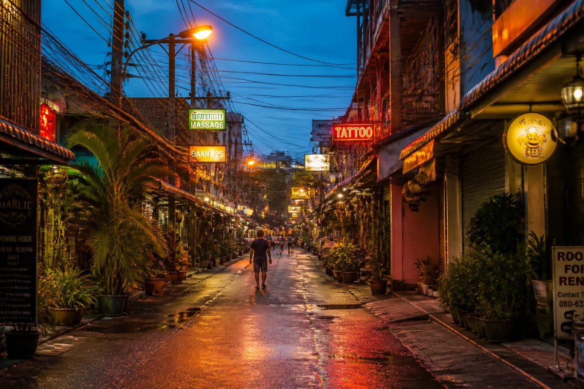 Ruelle urbaine animée en Thaïlande avec néons et câbles électriques, un endroit à éviter en Thaïlande.