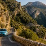 Voiture bleue circulant prudemment sur une route de montagne étroite et sinueuse, un endroit à éviter en Corse.